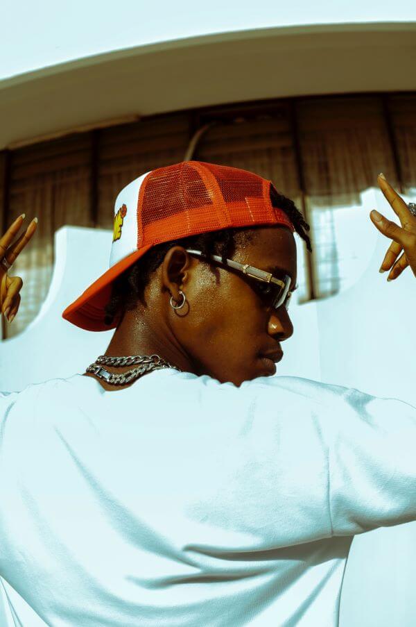 6 étapes pour créer une marque de mode streetwear à partir de zéro 2 Homme portant une casquette de baseball rouge et un pull de Pentecôte cool