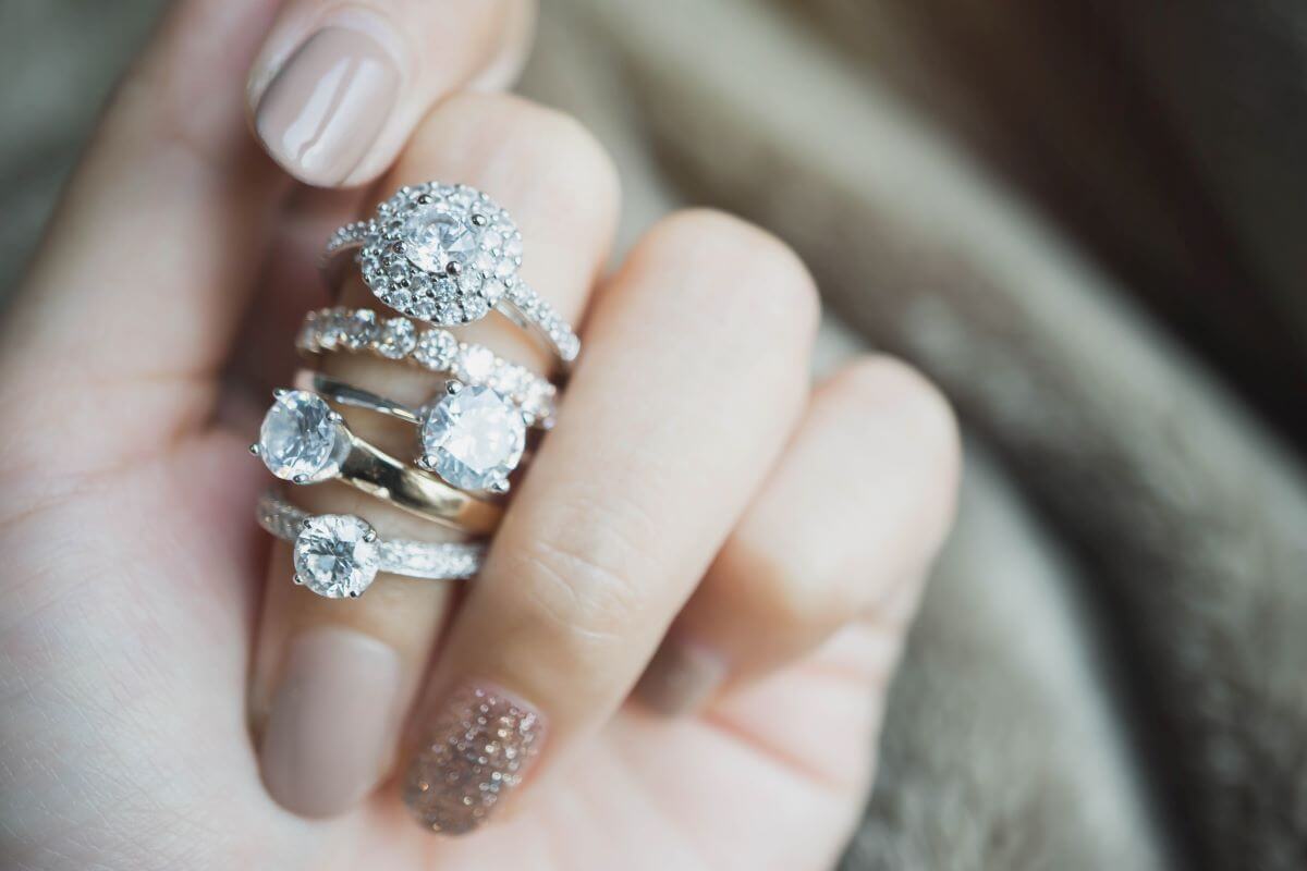 une main de femme avec des bagues de fiançailles en diamant