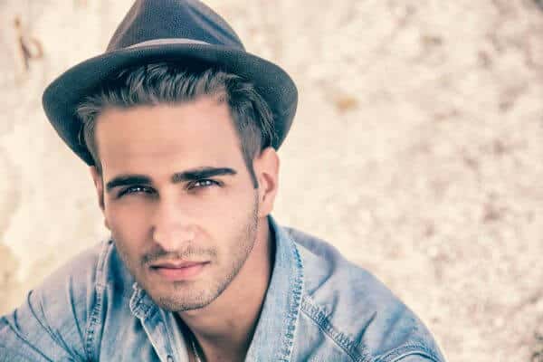 Jeune homme portant un chapeau trilby sombre