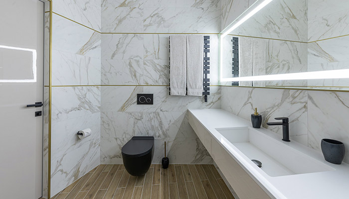 Salle de bain en marbre avec toilettes noires