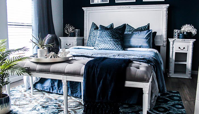Dans la chambre, une tête de lit classique en bois blanche