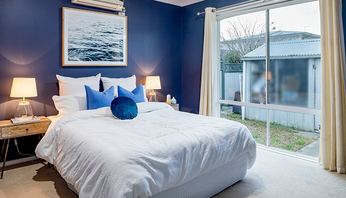 Une chambre avec un mur bleu foncé