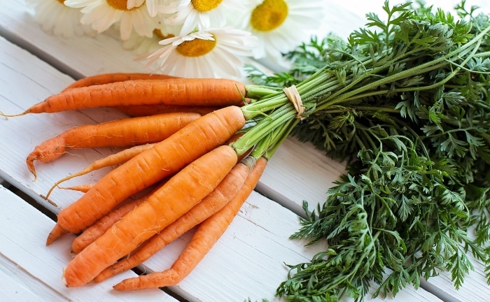 une chaîne de carottes sur une table en bois