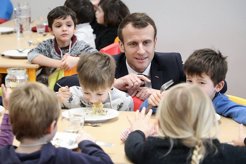 Le président français Emmanuel Macron rencontre des étudiants lors d'une visite dans une cantine scolaire à Saint-Sozy, dans le sud-ouest de la France