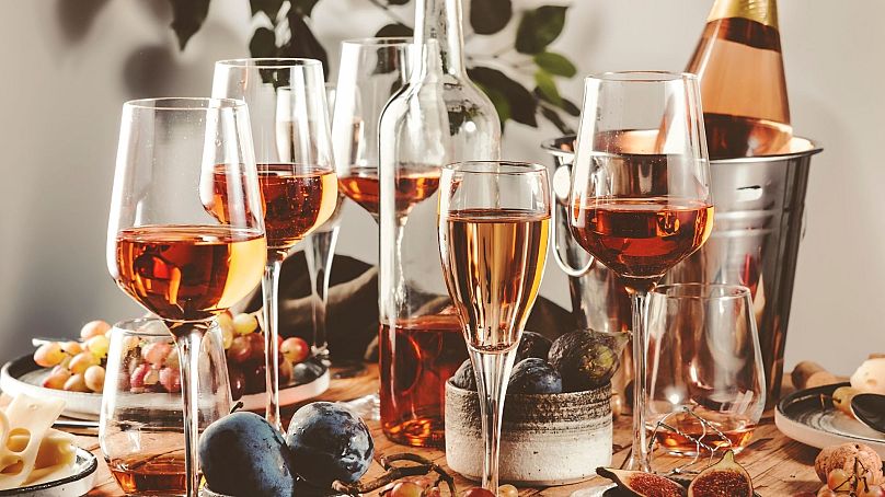 Verres à vin rosé et bouteilles sur la table