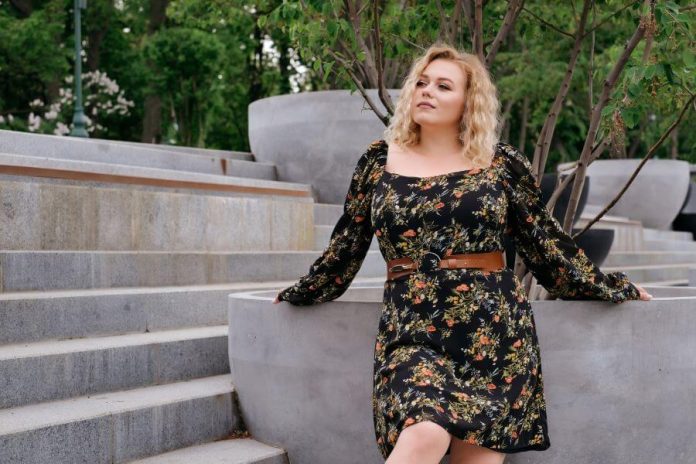 Femme ronde portant une robe à fleurs