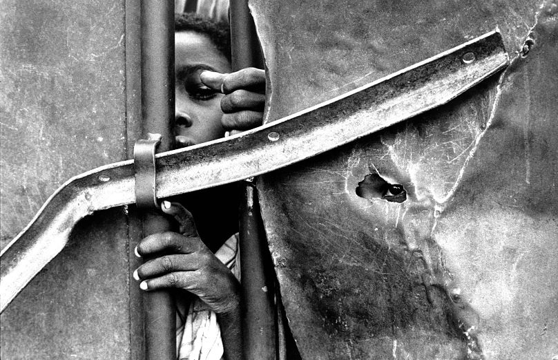 Des enfants regardent depuis les portes du centre de nutrition pendant une famine