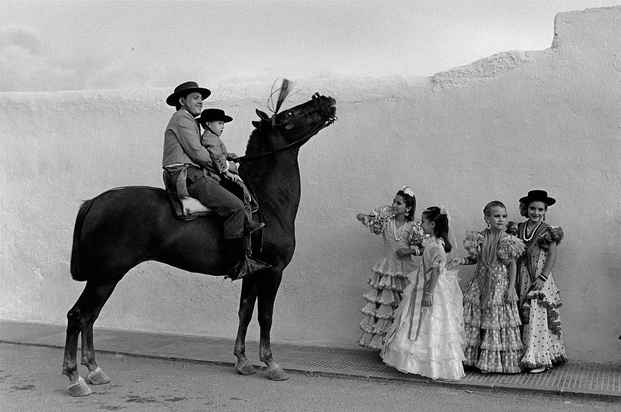 Des jeunes filles vêtues de vêtements traditionnels sévillans posent avec un cheval.