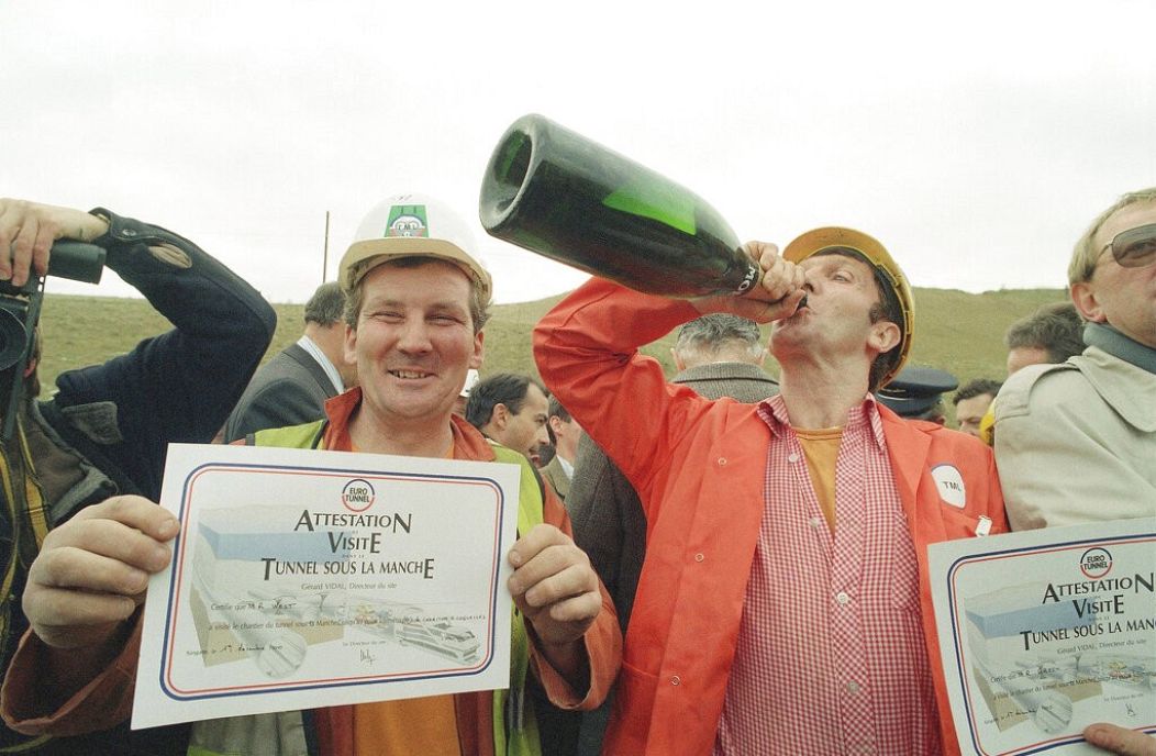 Lead Miner Roy West présente son certificat aux visiteurs alors que Shift Boss Ray Green boit du champagne pour célébrer l'inauguration du tunnel - Sangette, France. Décembre 1990